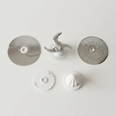 Various attachments of a compact food processor laid out on a clean surface, emphasizing versatility and small kitchen organization. 